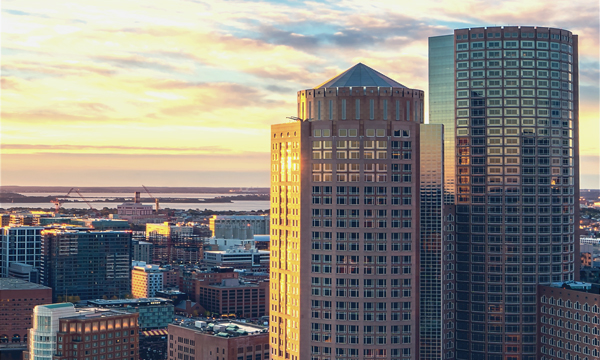 A stock photo of two buildings in Boston with the harbor in the background
