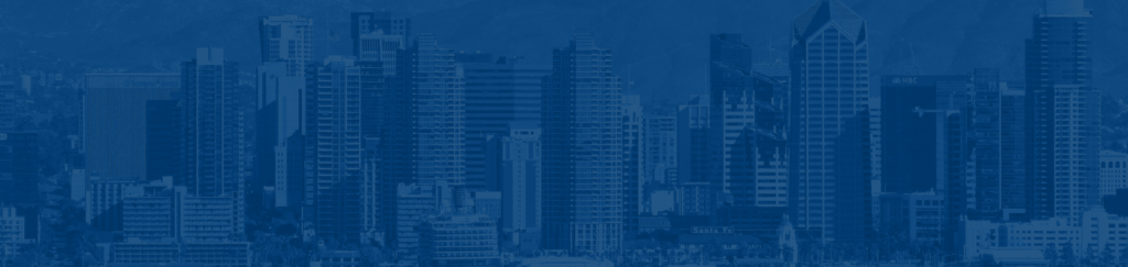 A photo of a city skyline taken from a distance with a blue tint over the photo